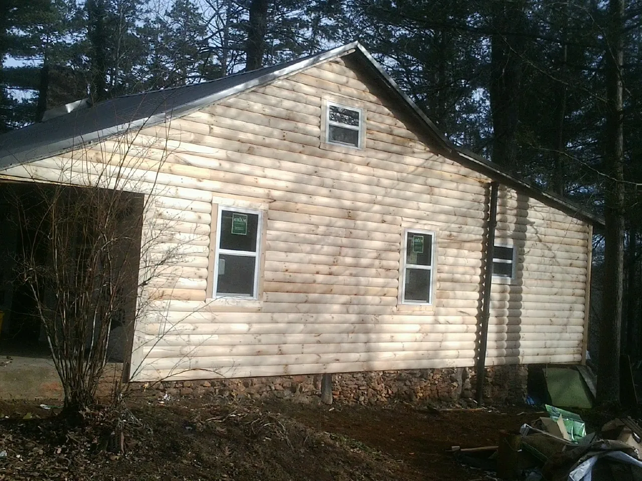 New log siding and dark metal roofing on a gable end in Camas Valley