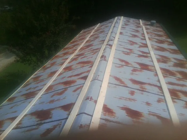 Rusted metal roof panels with new wood purlins before replacement — Storm Damage Roof Repair in Camas Valley by Roofing Brothers