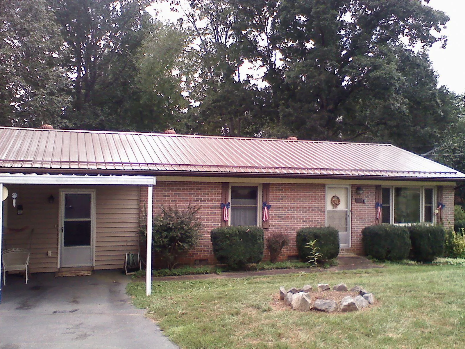 Bronze metal roof and carport on a brick ranch home — Roof Repair work by our crew in Camas Valley